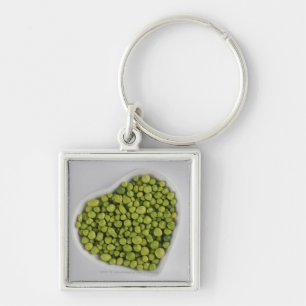 Close-up of green pebbles in a heart shape bowl key ring