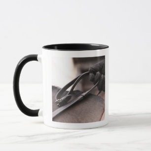 close-up of hand holding reins of horse mug