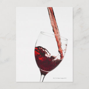 Close up of red wine being poured into glass on postcard