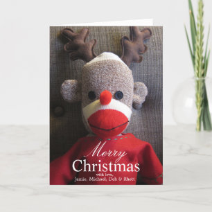 Close-up of sock monkey face with antlers, red holiday card
