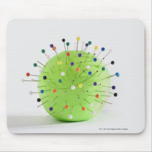 Close-up of straight pins inserted into a ball mouse pad