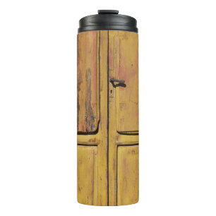 Closed brown wooden cabinet thermal tumbler