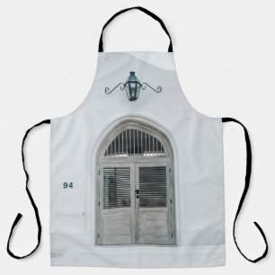 CLOSED GREY WOODEN DOOR BELOW BLACK LIGHT SCONCE APRON