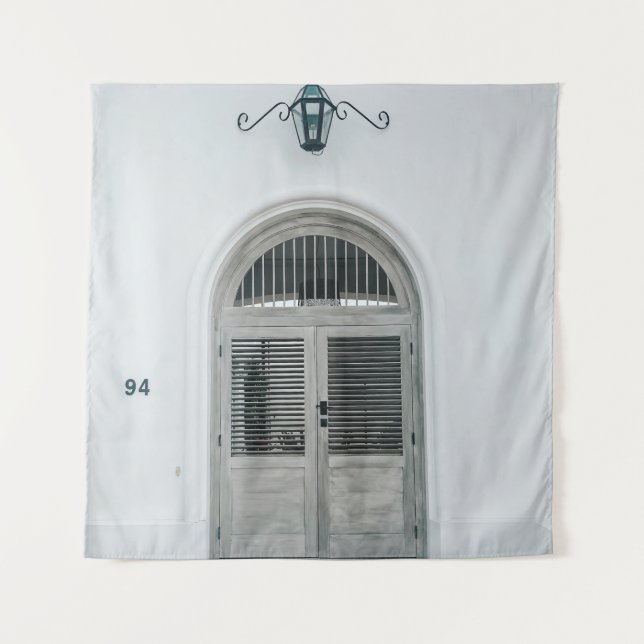 CLOSED GREY WOODEN DOOR BELOW BLACK LIGHT SCONCE TAPESTRY (Front)