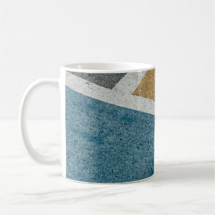 Closeup grey, yellow, and blue painted pavement coffee mug