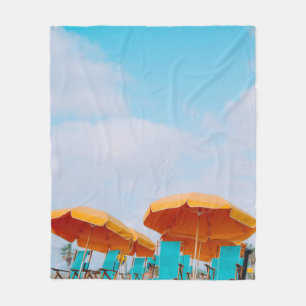 Closeup photo of lounger chairs and beach umbrella fleece blanket