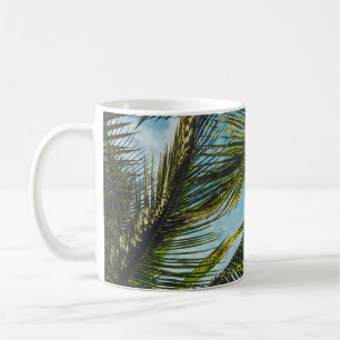 Coconut tree leaves under blue sky in the morning coffee mug