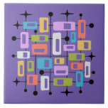 Colorful Retro Mid Century Modern Atomic Abstract Ceramic Tile<br><div class="desc">This artwork radiates mid-century modern energy, layering vibrant rectangles and squares of orange, green, blue, pink, purple, and white within a black grid of lines and dots. The composition is punctuated by playful black starbursts, evoking the optimism of the atomic age. Set against a deep purple background, the symmetry and...</div>