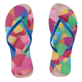 Colourful Beach Balls in Sand Flip Flops