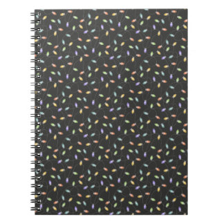 Colourful christmas lights garland pattern on blac notebook