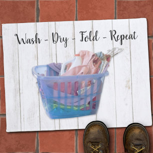 Colourful Folded Laundry On Hangers In Blue Basket Doormat