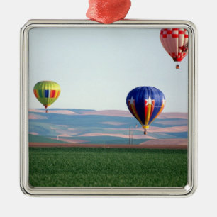 Colourful hot air balloons float over wheat metal tree decoration