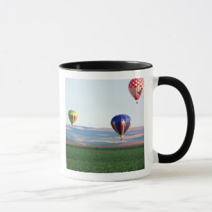 Colourful hot air balloons float over wheat mug