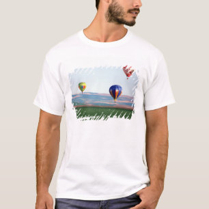 Colourful hot air balloons float over wheat T-Shirt