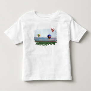 Colourful hot air balloons float over wheat toddler T-Shirt