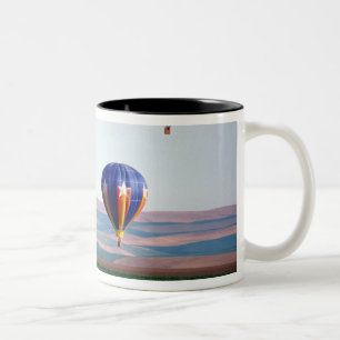 Colourful hot air balloons float over wheat Two-Tone coffee mug