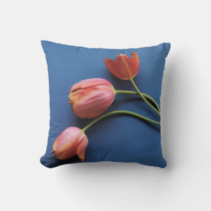 coral tulips on blue throw pillow