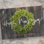 Country Rustic Wood Merry Happy New Year Holiday Card<br><div class="desc">Design is composed of a luscious green foliage wreath on a dark wooden background with a holiday greeting written in playful cursive script typography. 

Available here:
http://www.zazzle.com/store/selectpartysupplies</div>