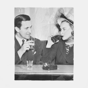 Couple sitting together in a restaurant flirting w fleece blanket