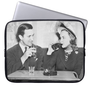 Couple sitting together in a restaurant flirting w laptop sleeve