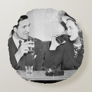 Couple sitting together in a restaurant flirting w round cushion