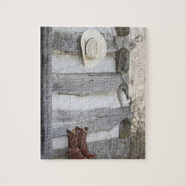 Cowboy boots and hat outside of log cabin jigsaw puzzle (Vertical)