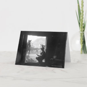 Cowboy in a doorway with horses card