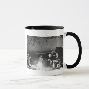 Cowboys playing and singing around a campfire mug