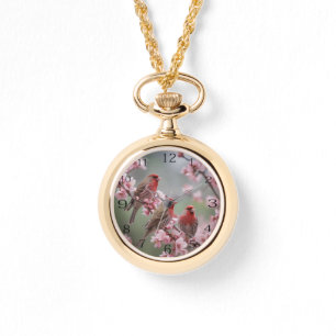 "Crimson Trio: Red Finches Amidst Pink Blooms" Watch