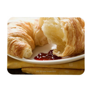 Croissant with jam on a plate magnet