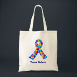 Custom Autism Awareness Ribbon Blue Team Name Tote Bag<br><div class="desc">Custom Autism awareness ribbon tote bag for autistic friends or family. A cool proud autism mum or dad gift that can be personalised with any text below the puzzle piece ribbon of blue,  yellow,  and red. A neat Asperger Syndrome pride present.</div>
