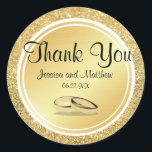 Custom Gold Glitter Thank You Wedding Stickers<br><div class="desc">Gold glitter and gold metallic circles create different visual textures to make a stunning gold thank you sticker. Thank you is written across the top in a pretty and ornate font. The bride and groom names and their wedding date are placed below. Two gold wedding rings complete the wedding seal....</div>