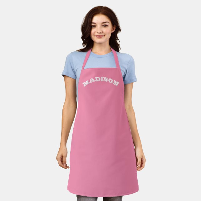 Customise name, text white curved letters pink apron (Worn)