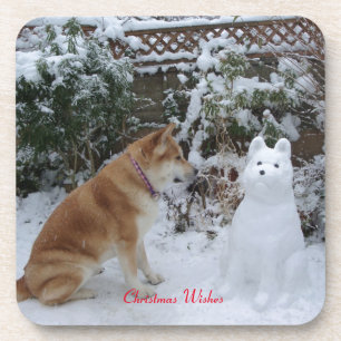 cute akita sitting with snowman in the snow dog coaster