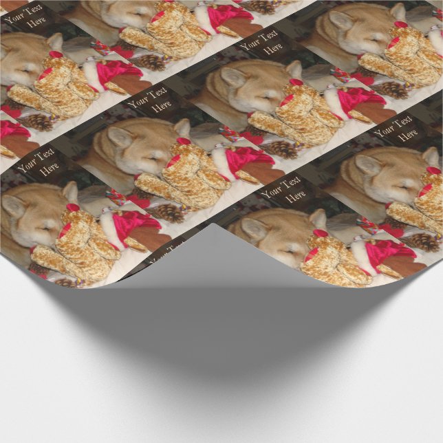 Cute dog asleep cuddling teddy at christmas wrapping paper (Corner)