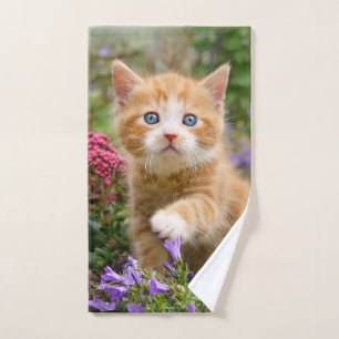 Cute ginger kitten in a garden playing with flower bath towel set