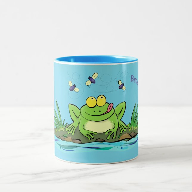 Cute green hungry frog cartoon illustration Two-Tone coffee mug (Center)