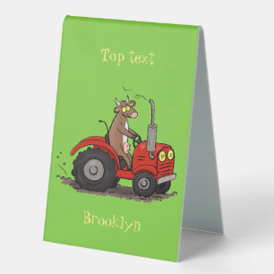 Cute happy cow driving a red tractor cartoon