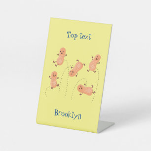 Cute happy jumping peanuts cartoon illustration pedestal sign