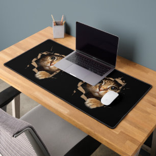 Cute kitten looks from torn fabric Cats Desk Mat