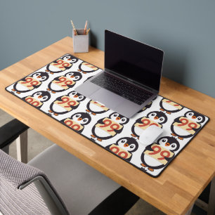 Cute penguin holding sign with the number 99 on it desk mat