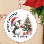 Cute Penguin Modern Personalised Merry Christmas Classic Round Sticker<br><div class="desc">Create stylish personalised white and red Christmas stickers for mailing seals,  favours or gift wraps with a design that says "Merry Christmas" and features a cute penguin in a red Santa hat decorating a Christmas tree. The template makes it easy to type your family name.</div>