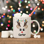 Cute Reindeer Boy Christmas Lights Custom Name Coffee Mug<br><div class="desc">Cute Christmas coffee or hot cocoa mug features an illustration of a sweet Rudolph reindeer boy face with a shiny red nose, eyelashes, and antlers. He is dressed up with a strand of colourful Christmas light bulbs and surrounded by light grey snowflakes. Personalise this festive hot chocolate mug with a...</div>