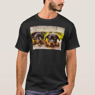 Cute Rottweiler Puppies Looking Through A Fence Di T-Shirt