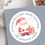 Cute Santa watercolor illustration family name Classic Round Sticker<br><div class="desc">Labels featuring an illustration of a cute Santa holding a gift,  and a custom holiday greeting and your name. Default text "Wishing you a very merry Christmas".</div>