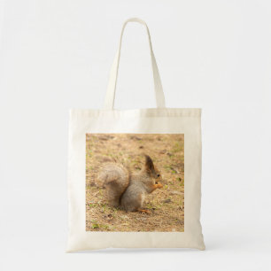 Cute squirrel eats a nut photo tote bag