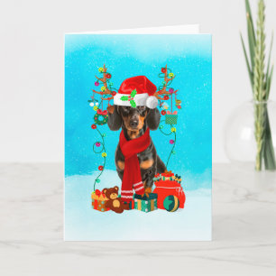 Dachshund in snow with Christmas gifts Card