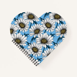 Daisies, wild flowers on blue notebook