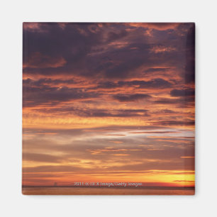 Dark clouds in orange streaked sky magnet