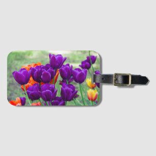 Dark purple tulips on a sunny day in the garden luggage tag